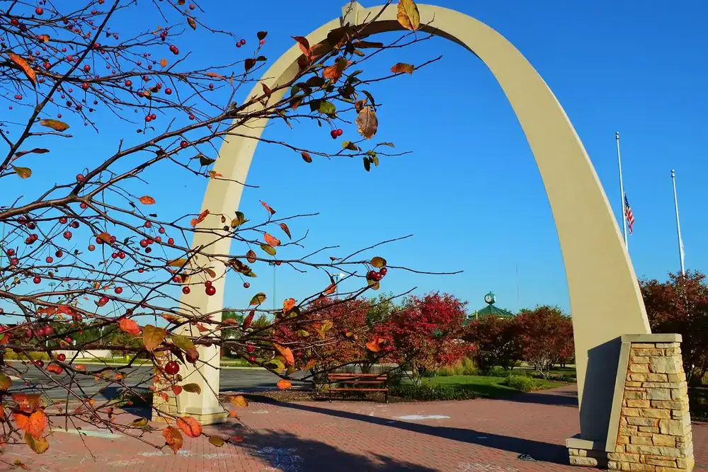 Tall stone arch framed by autumn branches and red berries in Carol Stream, Illinois