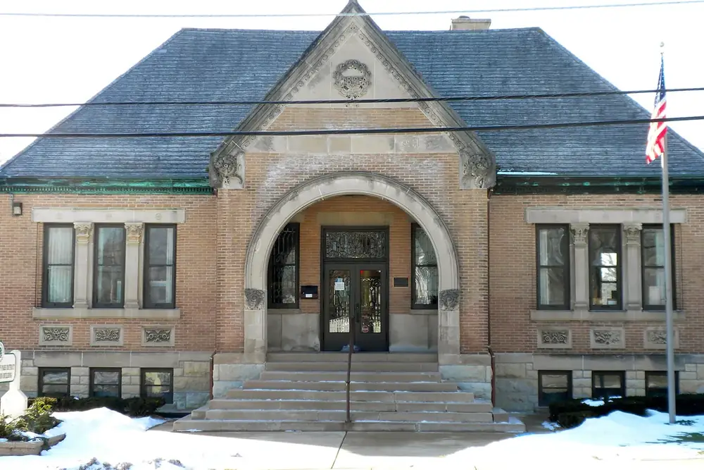Historic brick Library Hall with an arched stone entrance in Carpentersville, Illinois