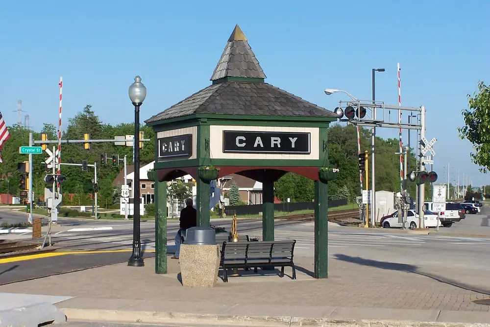 Green depot shelter with lamp posts beside the railroad crossing in Cary, Illinois