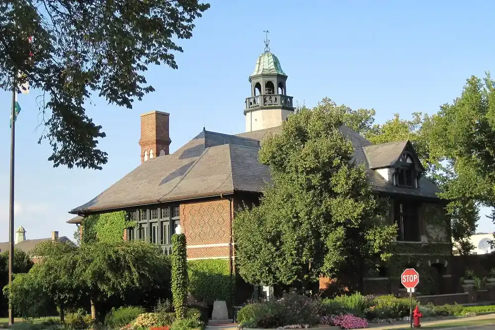Lake Forest City Hall with its cupola among summer trees and flowers, Illinois