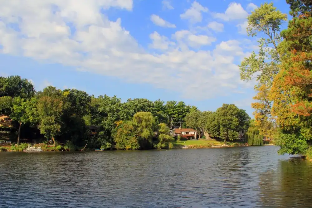 Woods Creek Lake edged by green and autumn trees in Lake in the Hills, Illinois