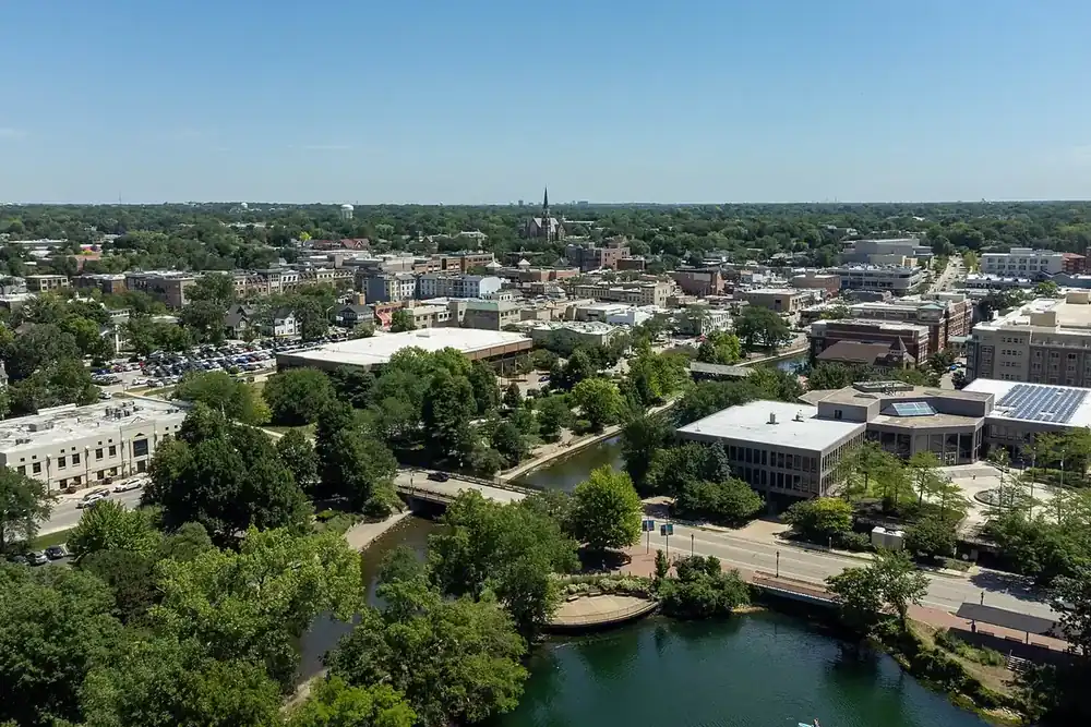 Aerial view of downtown Naperville and the DuPage River among green trees