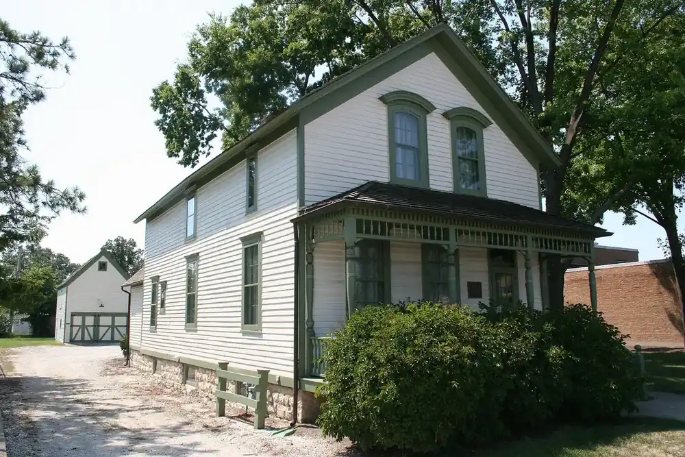 White historic Dorhmann-Buckman House museum among summer trees in River Grove, Illinois