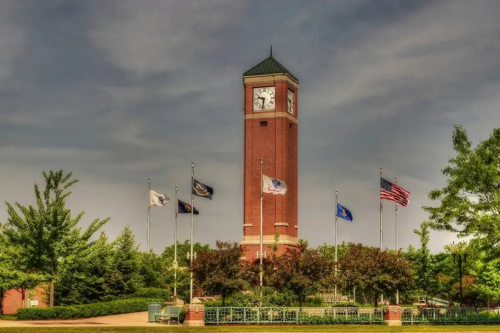 Brick clock tower and a row of flags among trees in Schaumburg, Illinois