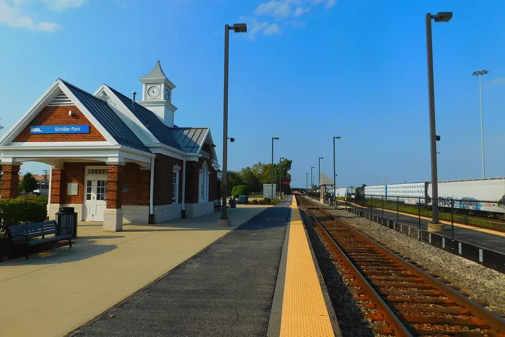 Brick train station with a clock cupola beside the platform in Schiller Park