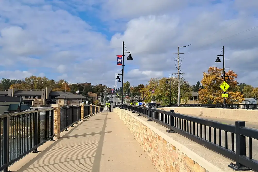 Walkway with black railings and lamp posts on the State Street bridge in South Elgin