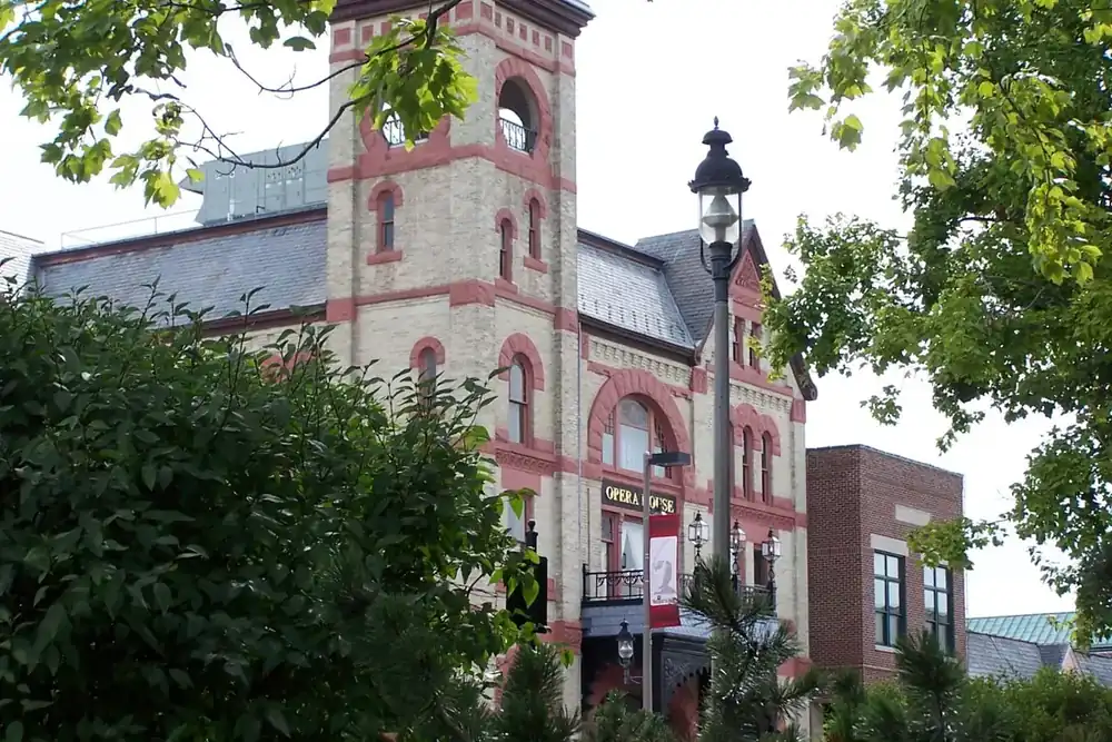 Historic Woodstock Opera House tower framed by summer trees in Woodstock, Illinois